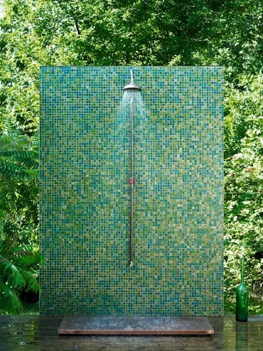 Летний душ, который сливается с растительностью на дачном участке.