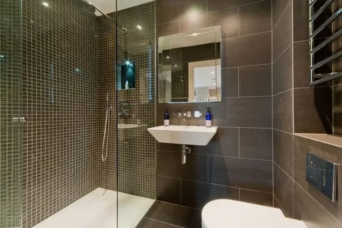 яркий декор ванной комнаты с душем в темных тонах